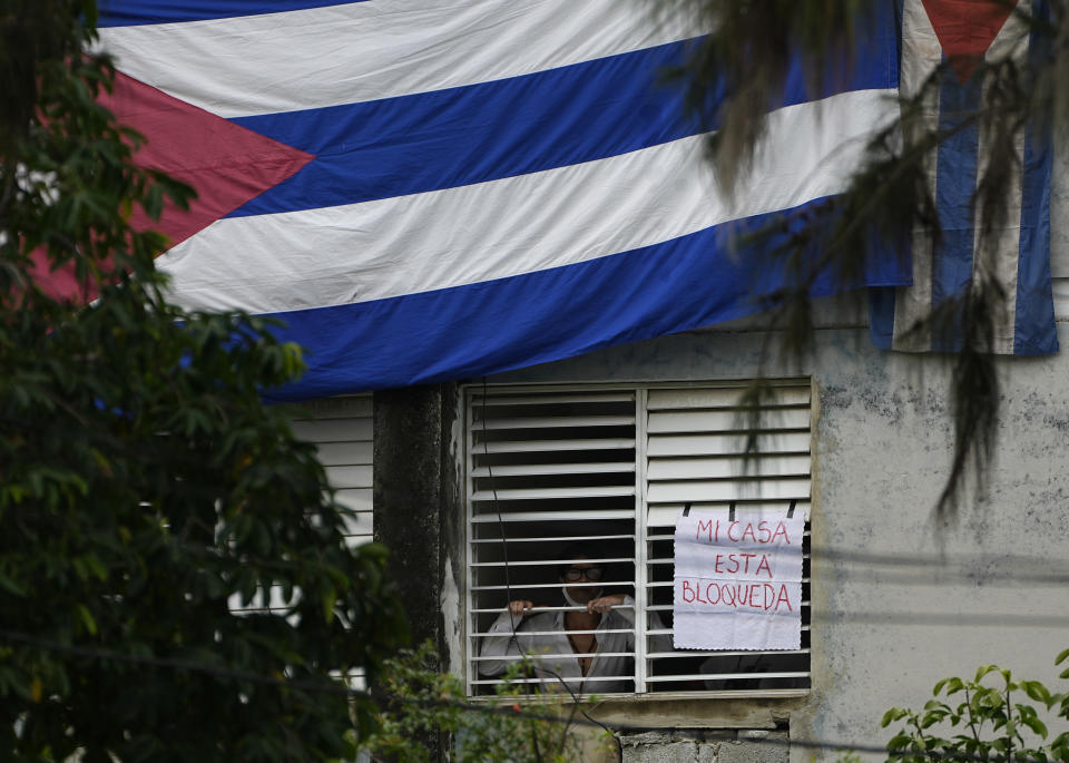 En esta fotografía de archivo, Yunior García, dramaturgo y uno de los organizadores de una marcha de protesta, junto a un cartel que dice en español "Mi casa está bloqueada", que colocó en una ventana de su casa, en La Habana, Cuba, el domingo el 14 de noviembre de 2021. García dijo el sábado 9 de julio de 2022 durante una entrevista con The Associated Press que aunque el gobierno no cayó en las protestas de 2021, estas sí lograron crear conciencia entre los cubanos. (AP Foto/Ramón Espinosa, Archivo)