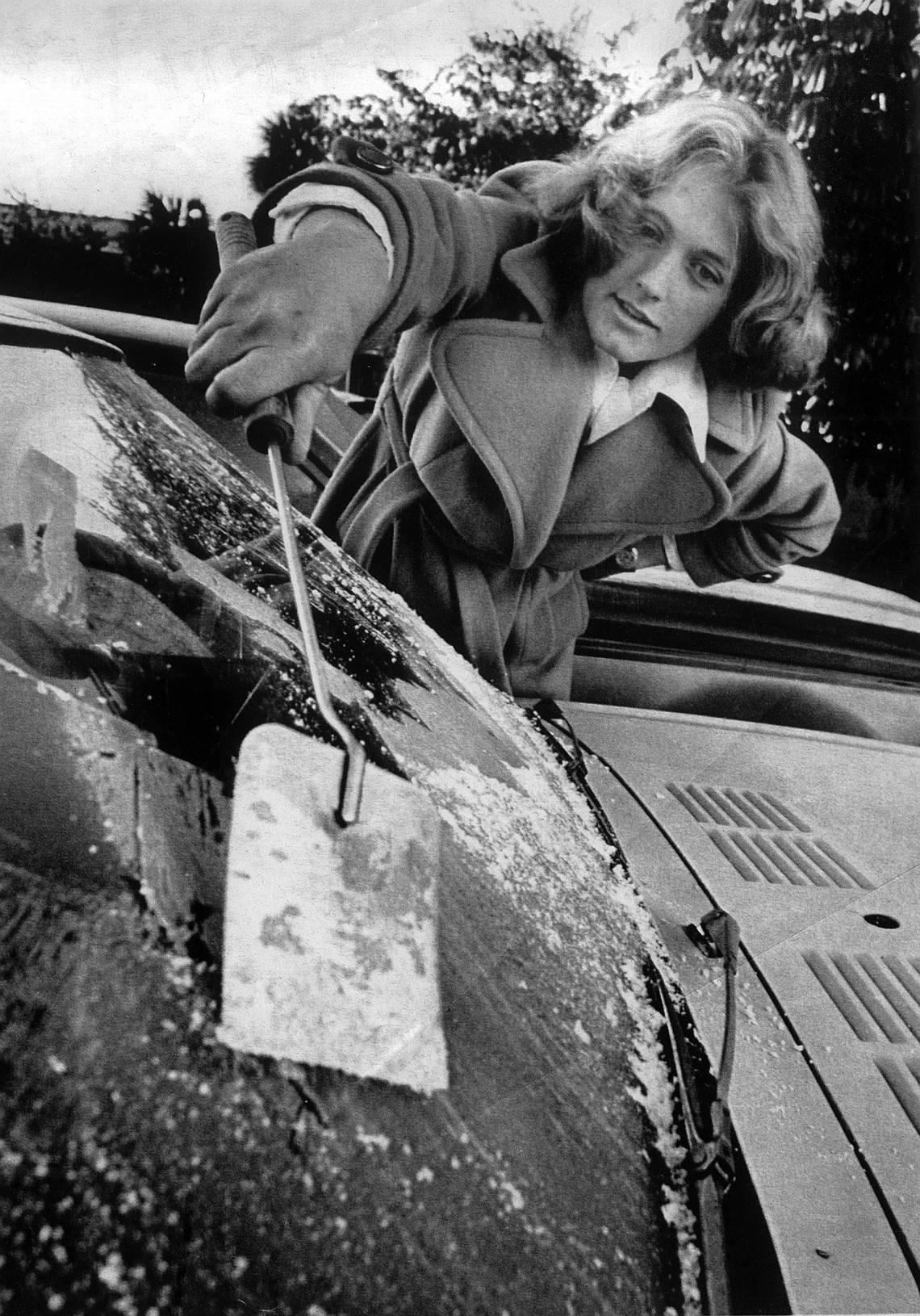 Connie Gramzow uses a cooking spatula to scrape ice from the windshield of her car in 31-degree weather.