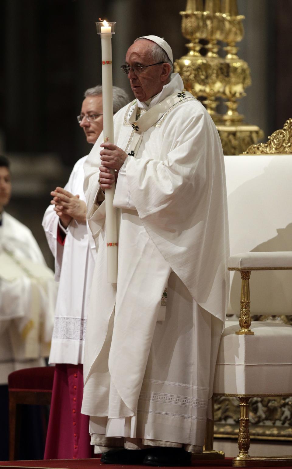 Pope Francis holds a candle as he presides over a solemn Easter vigil ceremony in St. Peter's Basilica at the Vatican, Saturday, April 15, 2017. (AP Photo/Andrew Medichini)