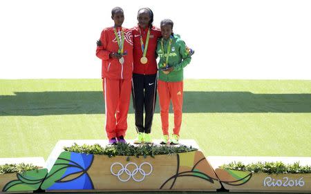 2016 Rio Olympics - Athletics - Victory Ceremony - Women's Marathon Victory Ceremony - Sambodromo - Rio de Janeiro, Brazil - 14/08/2016. Silver medallist Eunice Jepkirui Kirwa (BRN) of Bahrain, Gold medallist Jemima Sumgong (KEN) of Kenya and Bronze medallist Mare Dibaba (ETH) of Ethiopia stand on podium. REUTERS/Dominic Ebenbichler