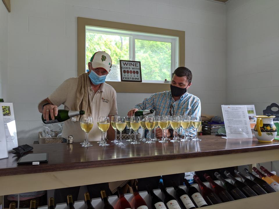 Sterling Gallagher and his son, Conor Gallagher, of Song Hill Winery, pour some wine for a socially distanced event in the summer of 2020 in Victor, N.Y.