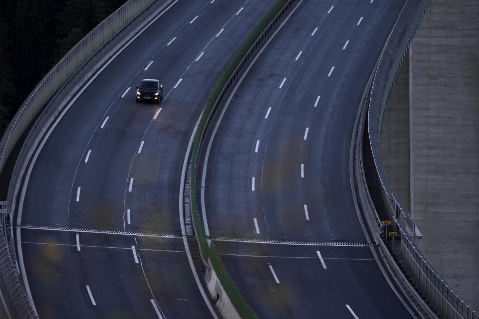 FILE - A car makes his way on an empty highway near Innsbruck, Austria, on Nov. 21, 2021. Austria went into a national lockdown to contain the fourth wave of coronavirus cases on Monday, Nov. 22. As countries across Europe reimpose lockdowns in response to surging COVID-19 cases and deaths, the UK – long one of Europe’s hardest-hit countries -- carries on with a policy of keeping everything as normal as possible. (AP Photo/Matthias Schrader)