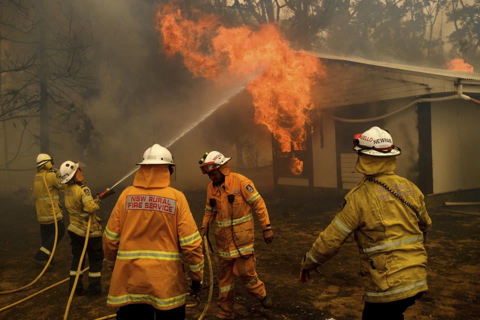 Firefighters battle the Morton Fire as it burns a home near Bundanoon, New South Wales, Australia, on Thursday, Jan. 23, 2020. (AP Photo/Noah Berger)