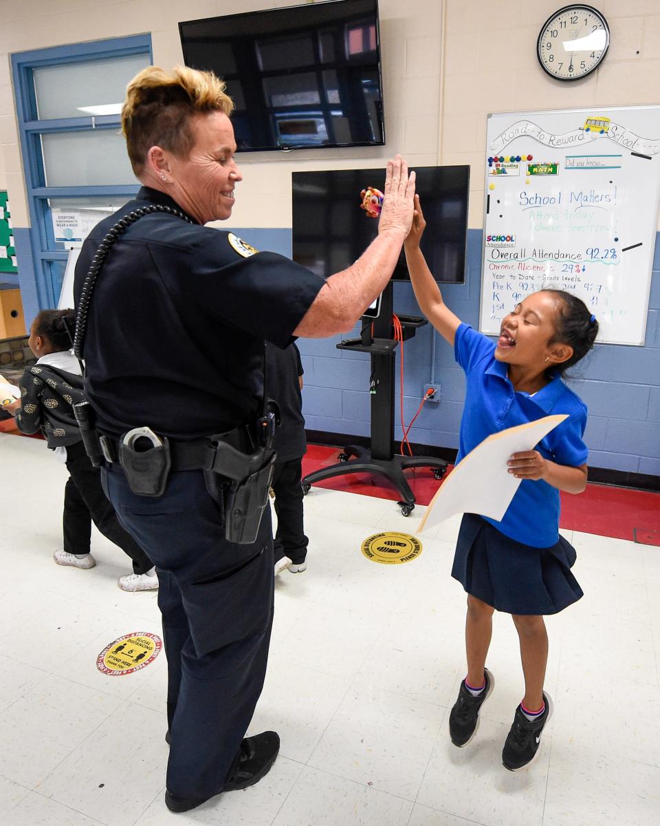 School Resource Officer Faye Okert high-five’s a student at Stratton Elementary School in Madison, Tenn. on Wednesday, May 25, 2022. Okert stopped by the school for an awards ceremony and end-of-the-year celebrations, and to check-in after a mass shooting in Texas left 19 children and two teachers dead the day before.