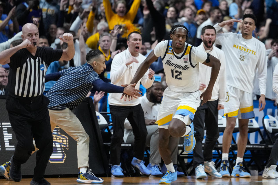 Marquette forward Olivier-Maxence Prosper (12) celebrates three-point basket with head coach Shaka Smart in the second half of a second-round college basketball game against Michigan State in the men's NCAA Tournament in Columbus, Ohio, Sunday, March 19, 2023. (AP Photo/Michael Conroy)
