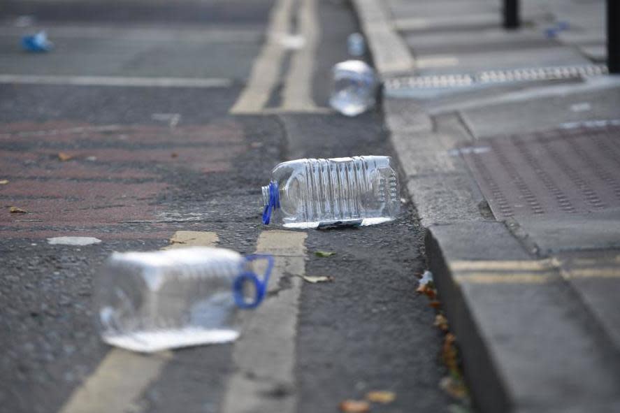 Empty water bottles are strewn across the ground at the scene of an acid attack in London: Jeremy Selwyn