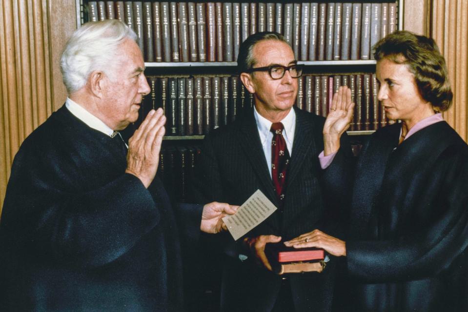 Justice Sandra Day O'Connor, the first female justice of the Supreme Court, is sworn in Sept. 25, 1981, by Chief Justice Warren Burger in the court's conference room in Washington. Justice O'Connor's husband, John, holds two family Bibles.