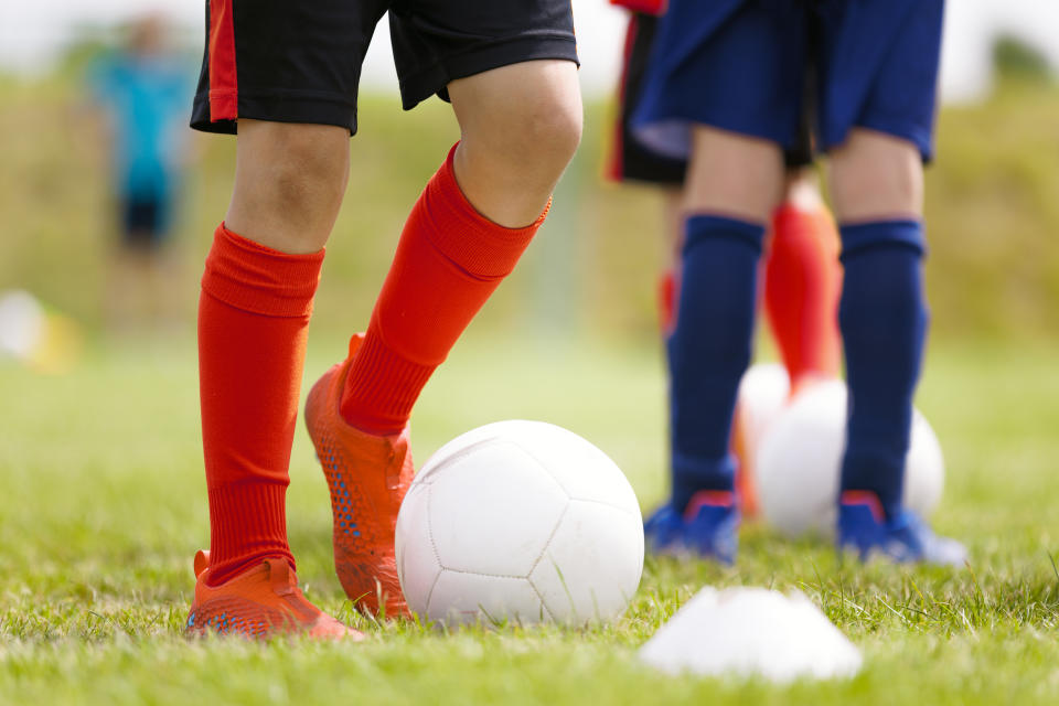 Soccer Players Kicking Classic White Soccer Balls on Training Session. Youth Football Background. Young Boy Wearing Soccer Cleats and Soccer Socks.