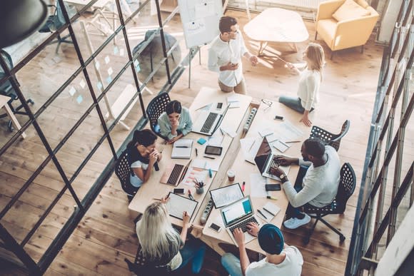 Overhead shot of young people working in modern office environment.