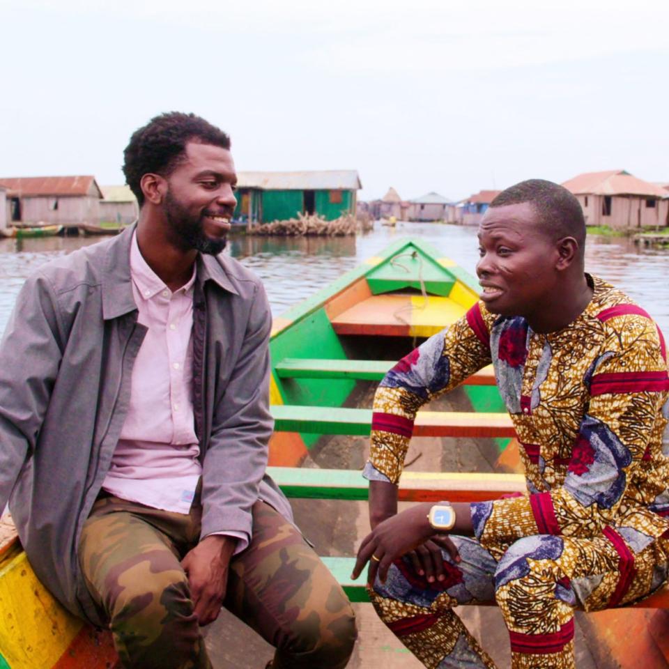 Satterfield (left) learns the history of Ganvié, Benin from local tour guide Eric Kiki.