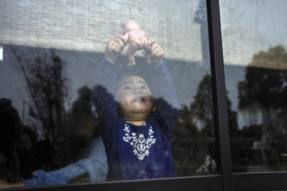 The 2-year-old daughter of Millaray Huichalaf, a Mapuche machi, or healer and spiritual guide, plays with a doll in their home in Carimallin, southern Chile, on Monday, June 20, 2022. (AP Photo/Rodrigo Abd)