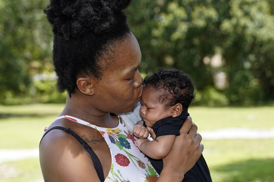 Venessa Aiken holds her son Jahzir Robinson, five weeks old, outside their home Sunday, Aug. 21, 2022, in Orlando, Fla. States around the country are making it easier for newborn moms to keep Medicaid in the year after childbirth, a crucial time when depression and other health problems can develop.(AP Photo/John Raoux)