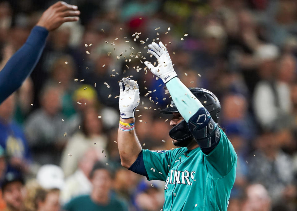 Seattle Mariners' Eugenio Suarez is showered with seeds as he returns to the dugout after hitting a solo home run against the Los Angeles Angels during the fifth inning of a baseball game Tuesday, Sept. 12, 2023, in Seattle. (AP Photo/Lindsey Wasson)