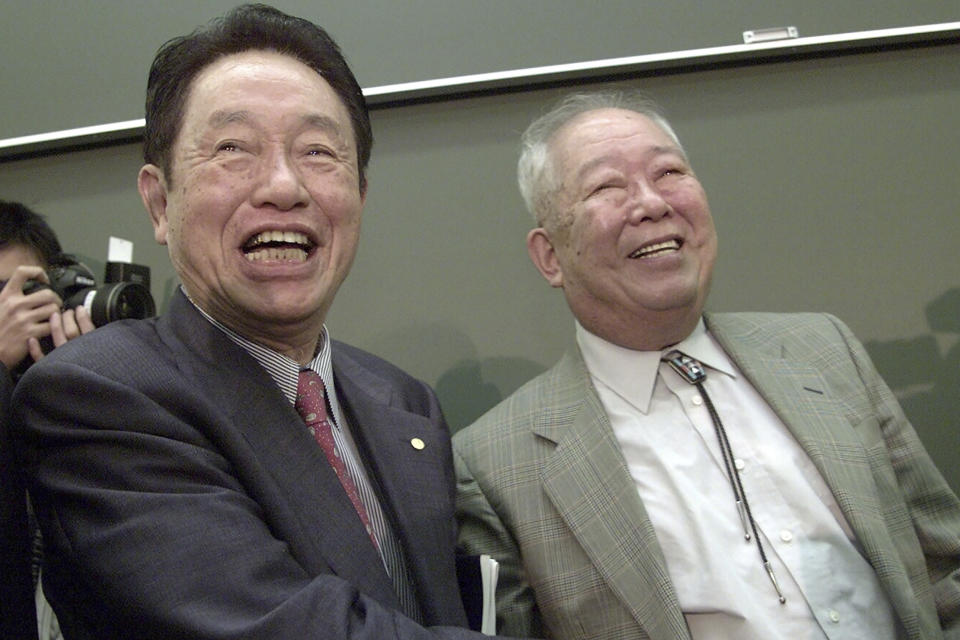 FILE - In this Oct. 8, 2002, file photo, Japanese physicist Masatoshi Koshiba, right, is congratulated by 1973 Nobel Prize winner in Physics Reona Ezaki after Koshiba won the Nobel Prize in Physics in 2002 at the University of Tokyo, in Tokyo. Koshiba, a co-winner of the Nobel Prize for his pioneering researches into the make-up of the universe, died Thursday, Nov. 12, 2020, the university said. He was 94. (AP Photo/Junji Kurokawa, File)