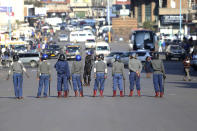 Zimbabwean riot police block a road ahead of a planned protest in Harare, Friday, Aug. 16, 2019. Zimbabwe's police patrolled the streets of the capital Friday morning while many residents stayed home fearing violence from an anti-government demonstration planned by the opposition. (AP Photo/Tsvangirayi Mukwazhi)