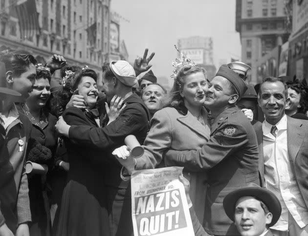 People celebrate on World War II Victory Day with a newspaper headline reading, 