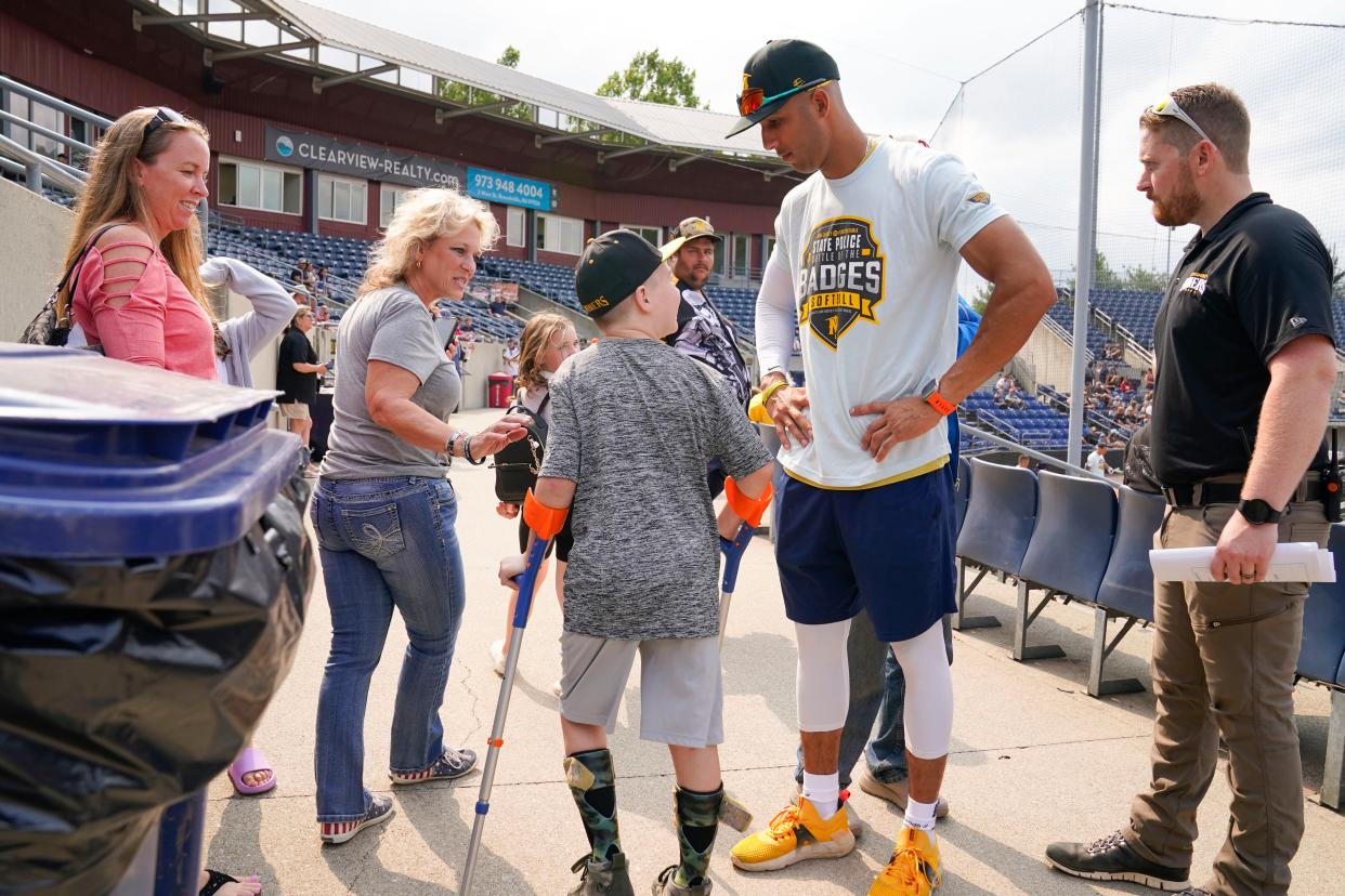 Cash Klem, center, greets New Jersey State Police Detective Miguel Hidalgo, second from right, before the Battle of the Badges charity softball game at Skylands Stadium on Thursday, August 3, 2023. Hidalgo, who signed a one-day contract with the Sussex County Miners, is donating his salary to help purchase a specialized wheelchair for Klem.