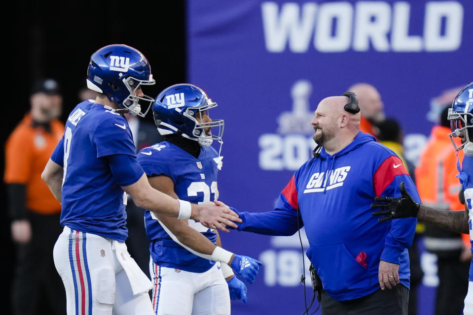 New York Giants quarterback Daniel Jones, left, is greeted by head coach Brian Daboll while leaving during the second half of an NFL football game against the Indianapolis Colts, Sunday, Jan. 1, 2023, in East Rutherford, N.J. (AP Photo/Seth Wenig)