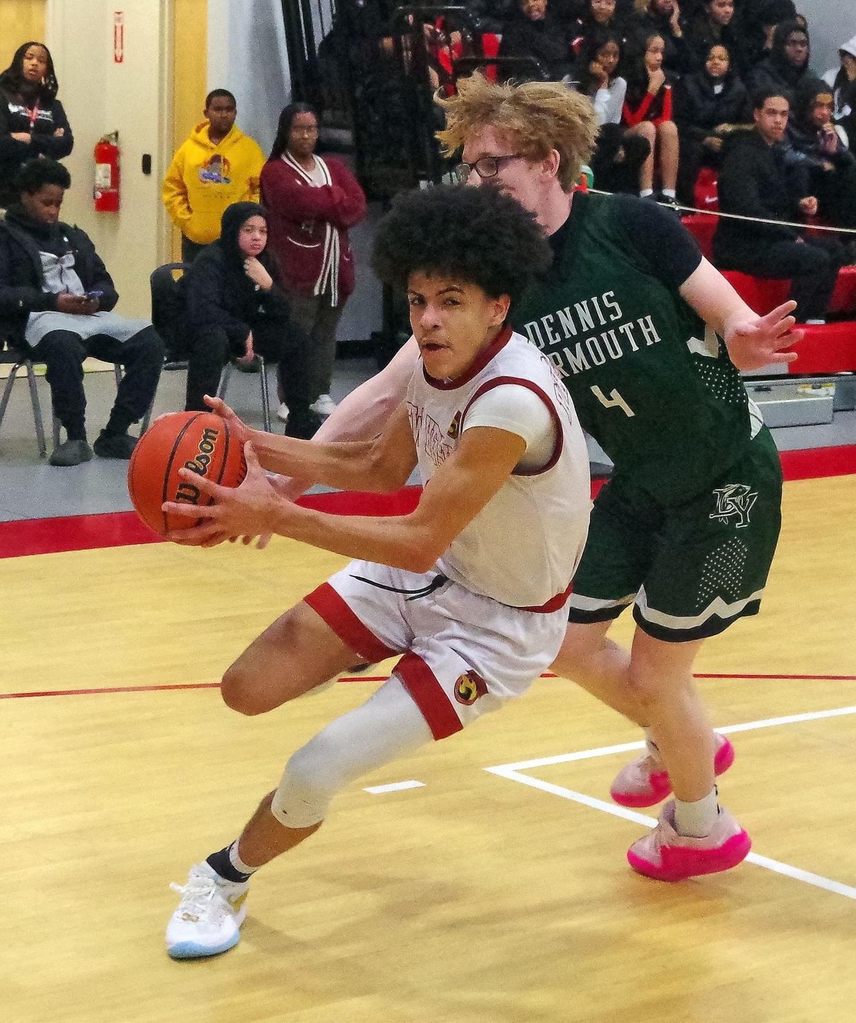 Christian Dalton of New Heights drives past Dennis Yarmouth defender Chris Beaton as Dalton heads to the basket in 1st half play on Thursday, Feb. 15, 2024.