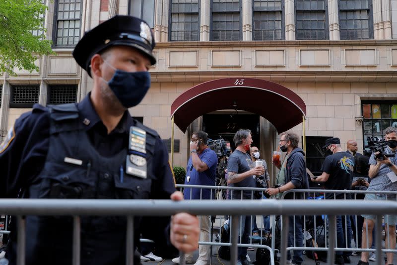 An officer from the New York Police Department (NYPD) places barricades outside the apartment building of Former New York City Mayor Rudy Giuliani, personal attorney to U.S. President Donald Trump, in Manhattan, New York City, New York