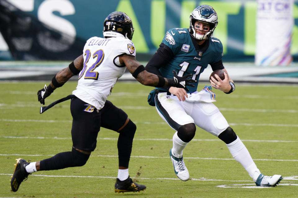 Philadelphia Eagles' Carson Wentz (11) tries to get past Baltimore Ravens' DeShon Elliott (32) during the first half of an NFL football game, Sunday, Oct. 18, 2020, in Philadelphia. (AP Photo/Chris Szagola)