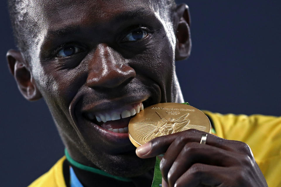 Gold medalist Usain Bolt of Jamaica bites his gold medal during the medal ceremony for the Men’s 4 x 100 meter Relay on Day 15 of the Rio 2016 Olympic Games at the Olympic Stadium on August 20, 2016 in Rio de Janeiro, Brazil.