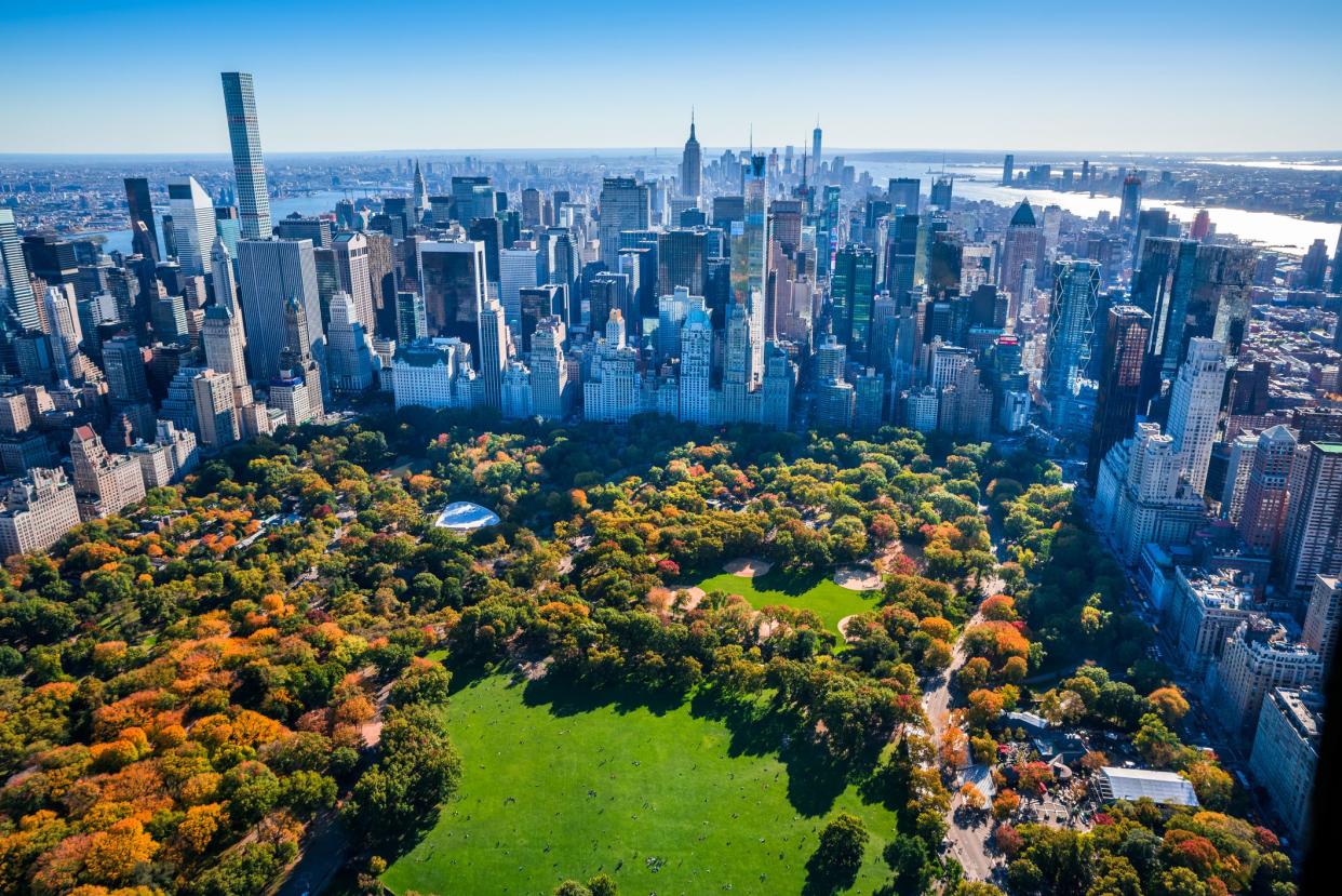 New York City skyline aerial view with Central Park in foreground and Manhattan cityscape skyline in background. Colorful autumn foliage in Central Park.