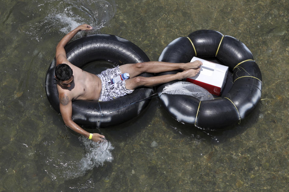 In a May 28, 2012 photo, a tuber floats down the Comal river Memorial Day in New Braunfels, Texas. Drinking beer while lazily floating through New Braunfels is a heat-beating tradition for hundreds of thousands of vacationers each summer, but turnout is down and businesses say the reason is clear: a new ban on disposable containers. The so-called can ban doesn’t prohibit alcohol, but that message hasn’t been sticking. (AP Photo/San Antonio Express-News, John Davenport) MAGS OUT NO SALES SAN ANTONIO OUT