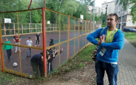 Soccer fan Pavel Cherkas, who was blacklisted by Russian authorities for bad behaviour at a stadium, stands near a football ground while wearing his 2018 World Cup fan ID, which was granted to Cherkas and later revoked, during an interview outside Moscow, Russia May 20, 2018. Picture taken May 20, 2018. REUTERS/Maxim Shemetov