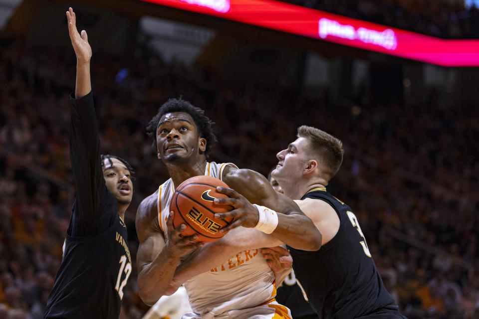Tennessee forward Tobe Awaka drives for a shot between Vanderbilt guard Evan Taylor (12) and guard Paul Lewis (3) during the first half of an NCAA college basketball game Saturday, Feb. 17, 2024, in Knoxville, Tenn. (AP Photo/Wade Payne)