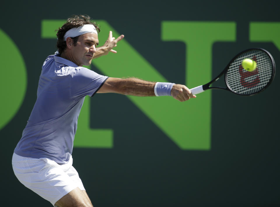 Roger Federer, of Switzerland, returns the ball to Ivo Karlovic, of Croatia, at the Sony Open tennis tournament, Friday, March 21, 2014, in Key Biscayne, Fla. Federer defeated Karlovic 6-4, 7-6 (7-4). (AP Photo/Lynne Sladky)