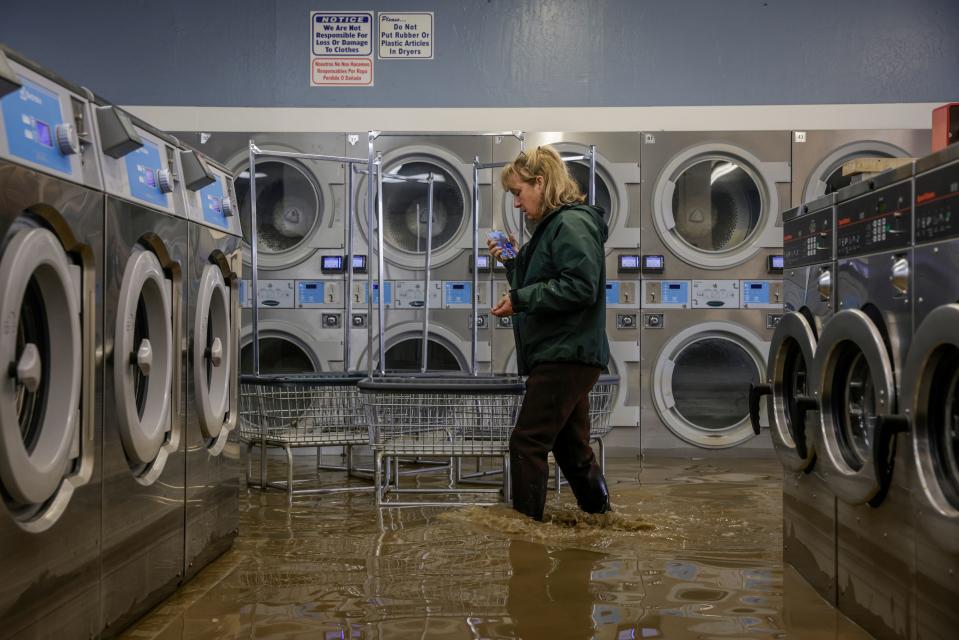 Pamela Cerruti walks through floodwaters in Pajaro, California, on Tuesday, March 14, 2023.