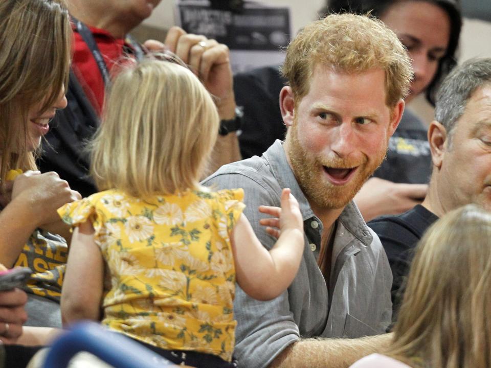 Prince Harry makes a face at a young girl