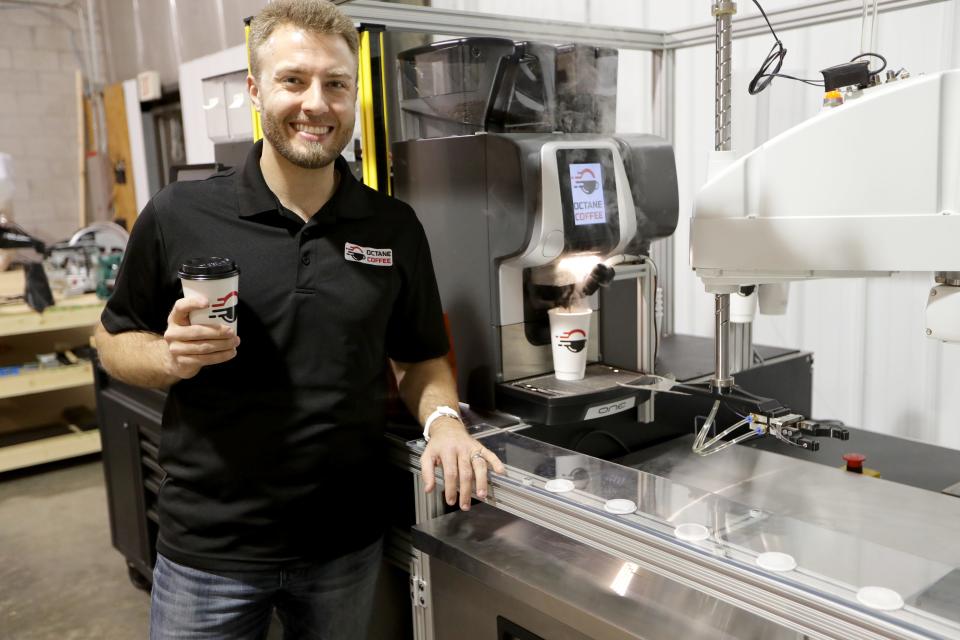 Adrian Deasy, Octane Coffee founder and CEO holds a freshly prepared cup of coffee as a cup is prepared behind with an automated drive-thru coffee machine at the facility Octane Coffee is using to build their automated drive-thru prototype coffee machines in Waukesha on Tuesday, March 16, 2021.   -  Photo by Mike De Sisti / Milwaukee Journal Sentinel via USA TODAY NETWORK