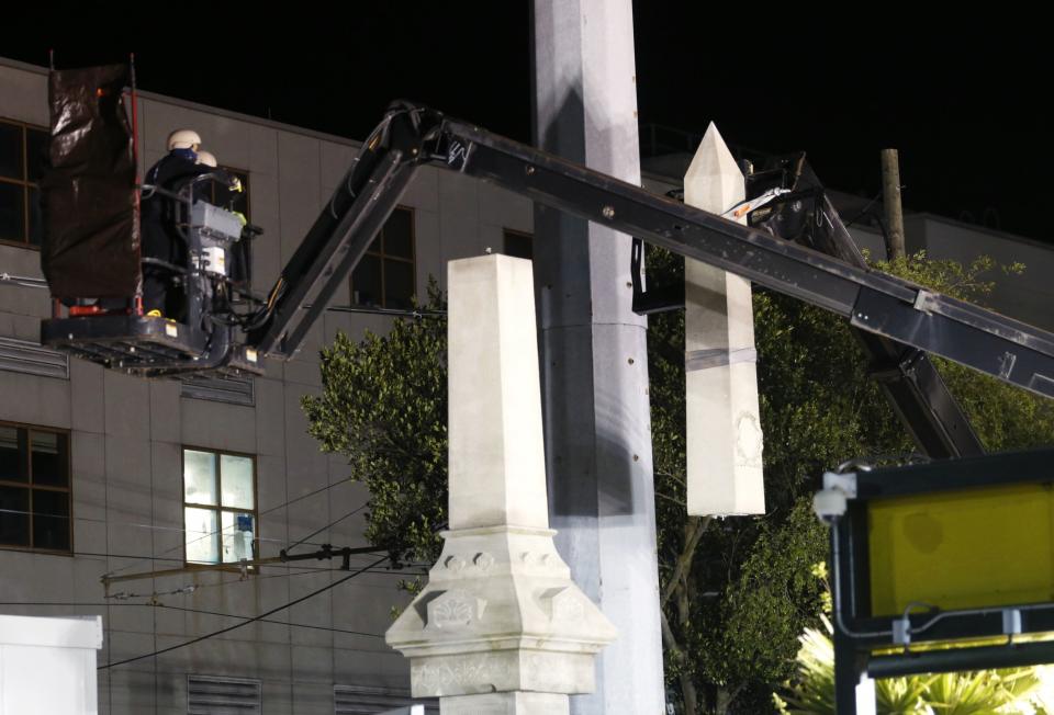 Workers dismantle the Liberty Place monument