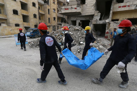 Rescue workers carry a body in Raqqa, Syria April 9, 2018. REUTERS/Aboud Hamam