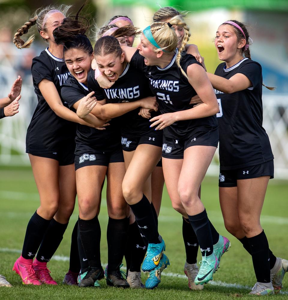 Lakeland Christian's Halle Johnson is hugged by teammates after scoring the winning goal against Shorecrest Prep on Friday in the Class 2A state final at Lake Myrtle Sports Complex in Auburndale.