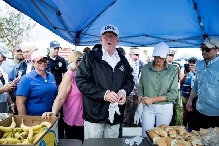 President Donald Trump and First Lady Melania Trump put on gloves before handing out sandwiches to victims of Hurricane Irma