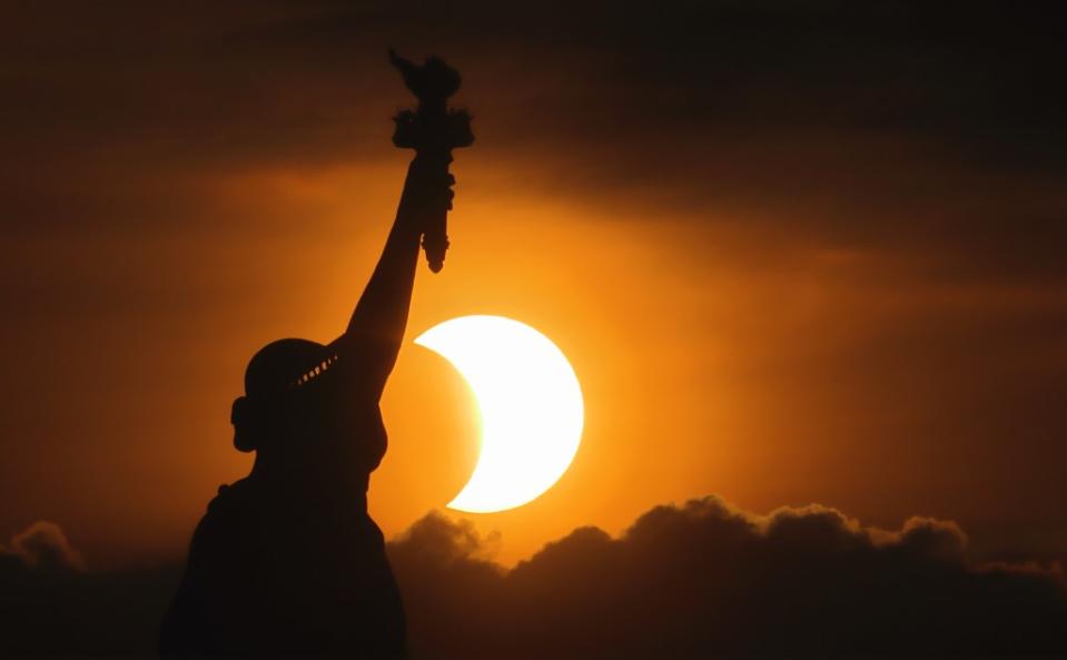 The sun rises next to the Statue of Liberty during an annular solar eclipse on June 10, 2021. Monday’s event promises to provide another dazzling display. Getty Images