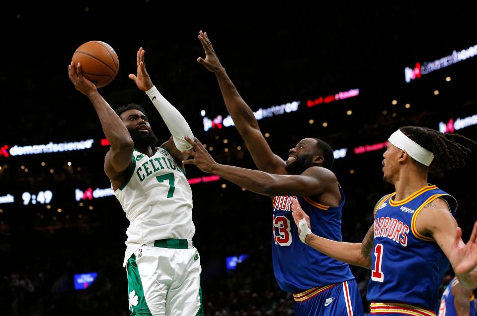 Celtics guard Jaylen Brown puts up a shot against Warriors forward Draymond Green during the second half of Friday night's game at TD Garden.