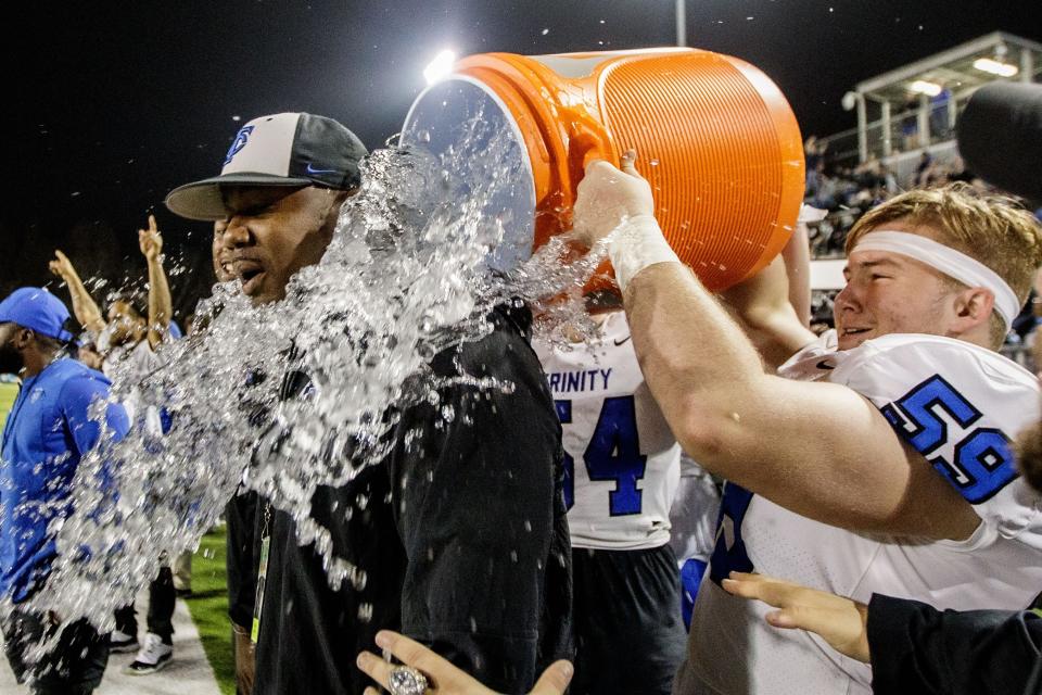 Trinity Christian players dump a bucket of water on offensive coordinator Gerard Ross to celebrate the team's victory. Trinity Christian defeated Champagnat 41-23 to claim the Class 2A State Championship title at Gene Cox on Thursday, Dec. 9, 2021.