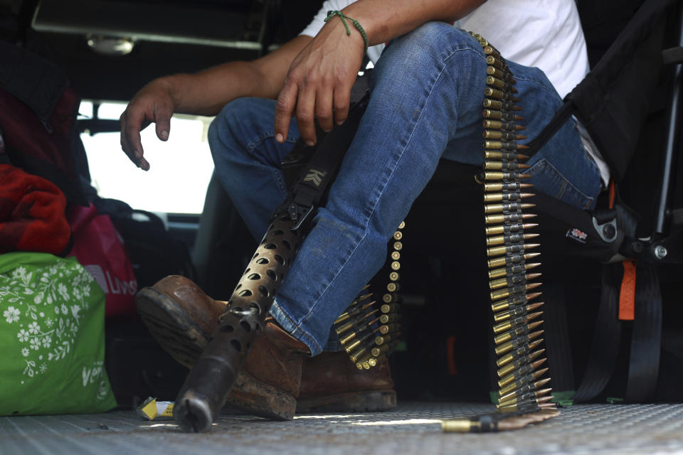 A member of the so-called self-defense group known as United Towns or Pueblos Unidos, sits with his ammunition during a rally in Nuevo Urecho, in the Mexican western state of Michoacan, Saturday Nov. 27, 2021. Extortion of avocado growers in western Mexico has gotten so bad that 500 vigilantes from the "self-defense" group gathered Saturday and pledged to aid police. (AP Photo/Armando Solis)