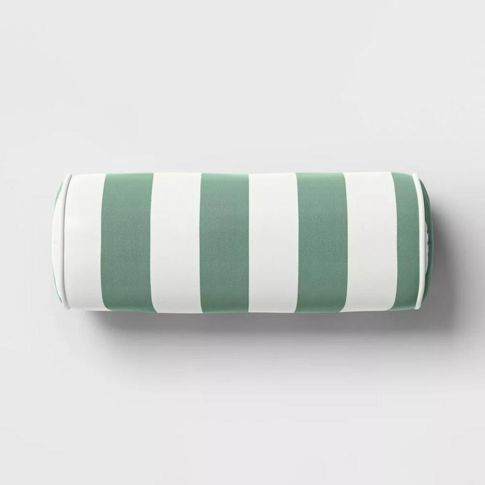 Striped cylindrical bolster pillow on a plain background