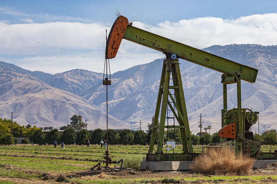 Les élèves marchent à travers le champ cultivé avec puits de pétrole à Arvin High School, Arvin, High School, comté de Kern, Californie, États-Unis.  (Photo par : Citizen of the Planet/UCG/Universal Images Group via Getty Images)