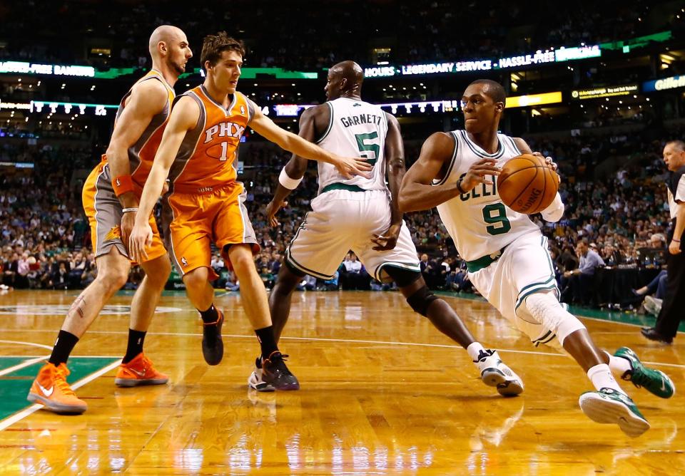 BOSTON, MA - JANUARY 9:  Rajon Rondo #9 of the Boston Celtics runs around his teammate Kevin Garnett #5 with the ball against the Phoenix Suns during the game on January 9, 2013 at TD Garden in Boston, Massachusetts. NOTE TO USER: User expressly acknowledges and agrees that, by downloading and or using this photograph, User is consenting to the terms and conditions of the Getty Images License Agreement. (Photo by Jared Wickerham/Getty Images)