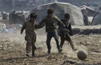 <p>Pakistani children play football at a slum in Lahore on Jan. 30, 2018. Photo from Arif Ali/AFP/Getty Images. </p>