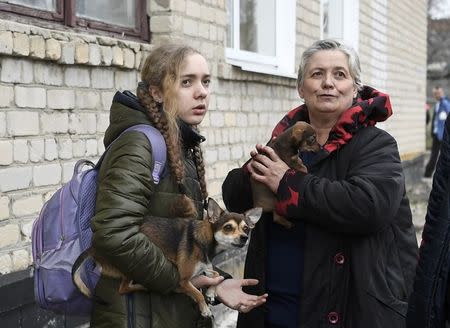 Local residents hold their dogs at a collection point for evacuees after ammunition detonated at a military base in the town of Balaklia (Balakleya), Kharkiv region, Ukraine, March 23, 2017. REUTERS/Vladyslav Musiienko/Pool