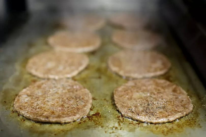 McDonald's burgers cooking on the grill (stock)