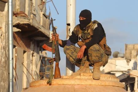 A member of al Qaeda's Nusra Front carries his weapon as he squats in the town of the northwestern city of Ariha, after a coalition of insurgent groups seized the area in Idlib province May 29, 2015. REUTERS/Ammar Abdullah