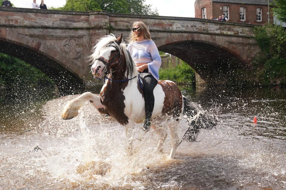 A traveller rides a horse in the River Eden at the Appleby Horse Fair, the annual gathering of gypsies and travellers in Appleby, Cumbria.